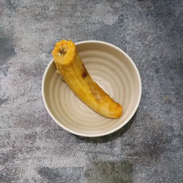 Hancurkan pisang tanduk dengan garpu.