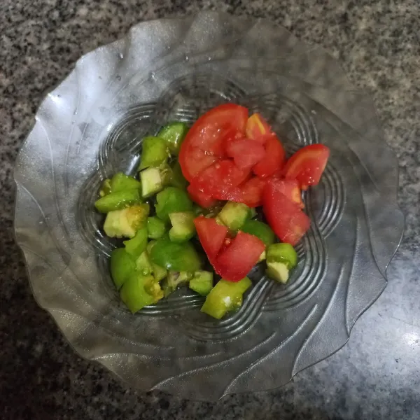 Potong dadu kecil tomat merah dan tomat hijau.