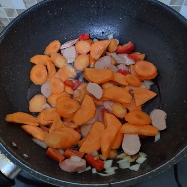 Masukan wortel yang sudah diiris tipis dan tambahkan sedikit air agar wortel cepat matang.