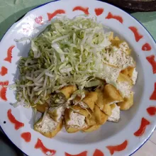 Tata nasi, tahu yang dipotong-potong, kubis, taoge lalu siram dengan bumbu kacang. Beri seledri dan kerupuk, lalu sajikan.