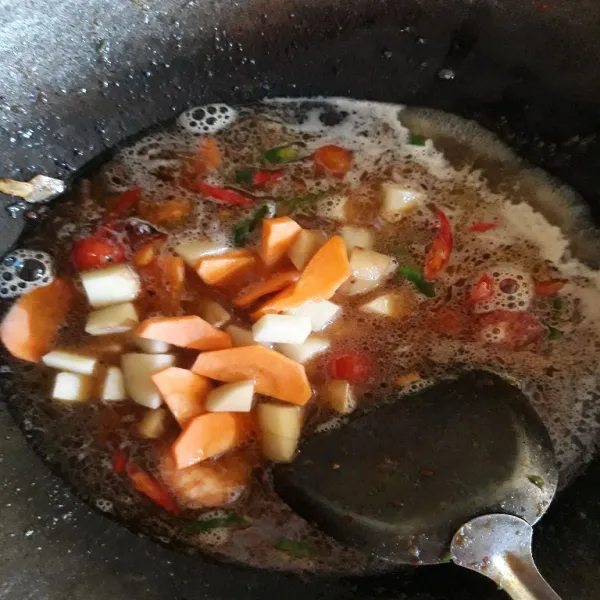 Masukkan wortel, kentang, dan air. Lalu beri saus, lada bubuk, kaldu, dan garam.