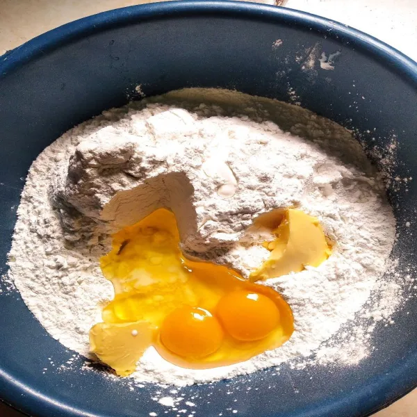 Masukkan tepung ketan, telur, dan mentega.