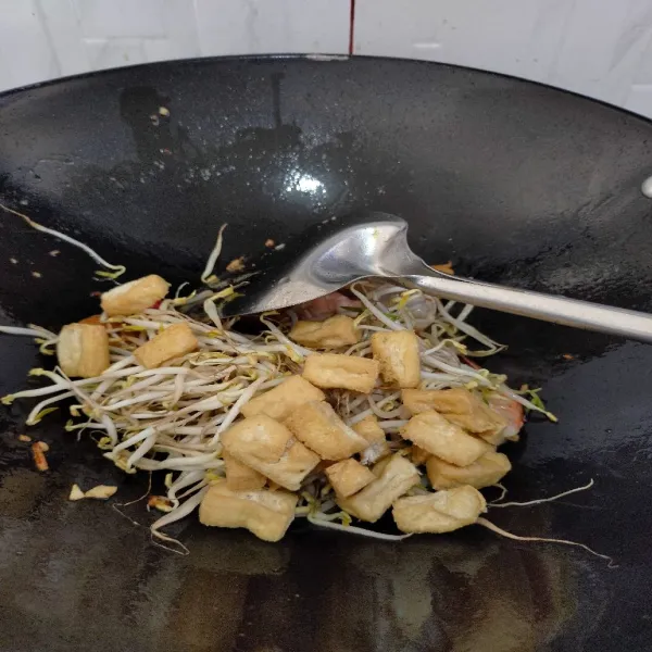 Tambahkan toge dan tahu yang sudah digoreng sebelumnya.