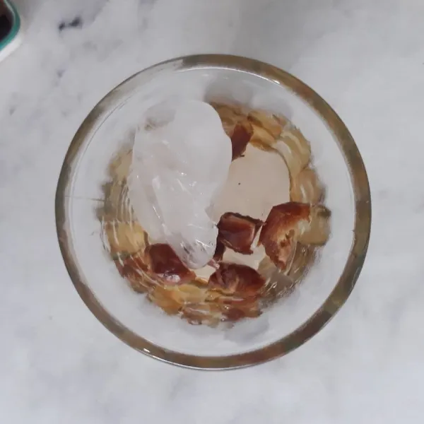 Tambahkan es batu dan potongan kurma ke dalam gelas.