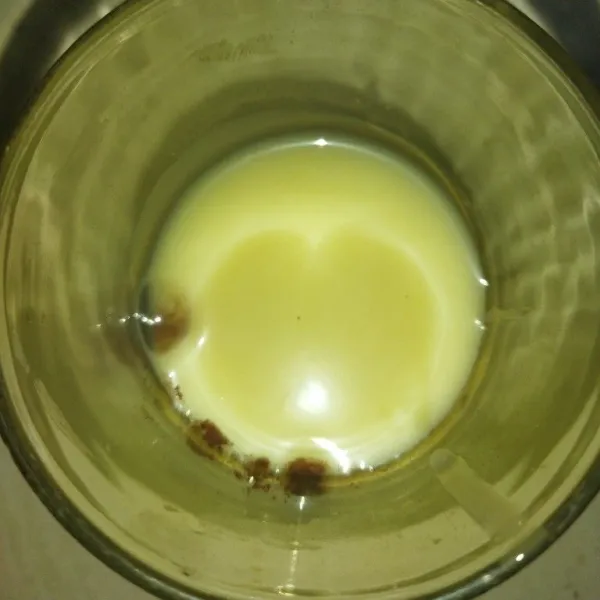 Siapkan gelas, lalu tuang coklat bubuk dan krimer kental manis.
