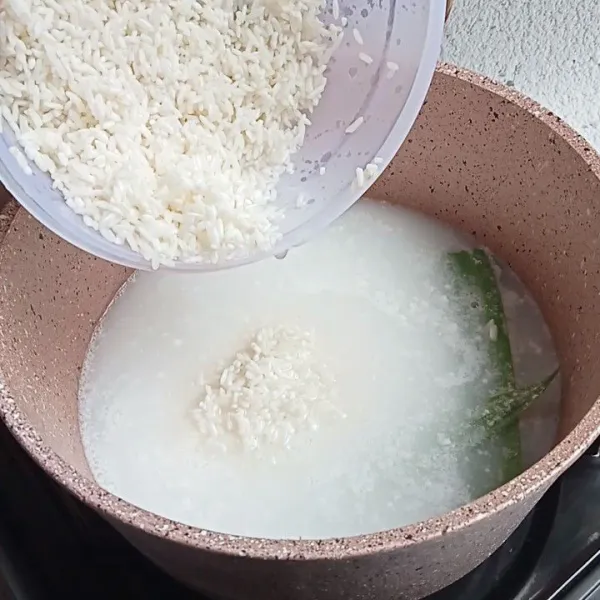 Setelah mendidih, masukkan beras yang sudah dicuci. Aron beras hingga airnya asat.