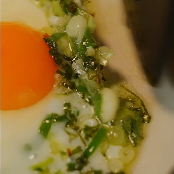 Siapkan panci, lalu masukkan minyak. Tumis daun bawang hingga wangi dan agak kecoklatan, lalu masukkan telur. Goreng hingga ujung telur garing.