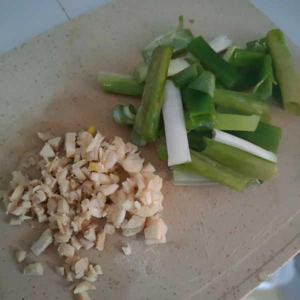 Cincang jahe dan bawang putih, kemudian potong daun bawang.
