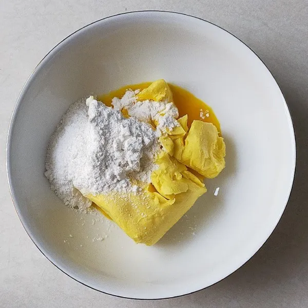 Campur dalam wadah butter, margarin, gula, dan kuning telur.
