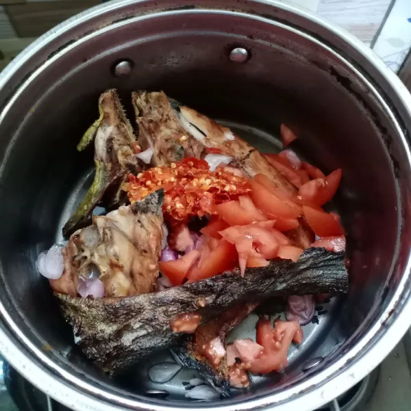 Dalam panci, aduk ikan asap, bumbu halus, irisan tomat, dan bawang merah.