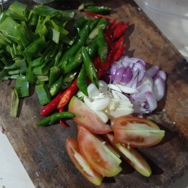Iris bawang merah, bawang putih, tomat, cabe, dan daun bawang, lalu sisihkan.