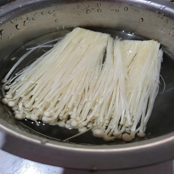 Potong bagian bawah jamur enoki, potong jamur enoki dan cuci bersih, kemudian rendam jamur enoki pada air yang telah diberi sedikit garam