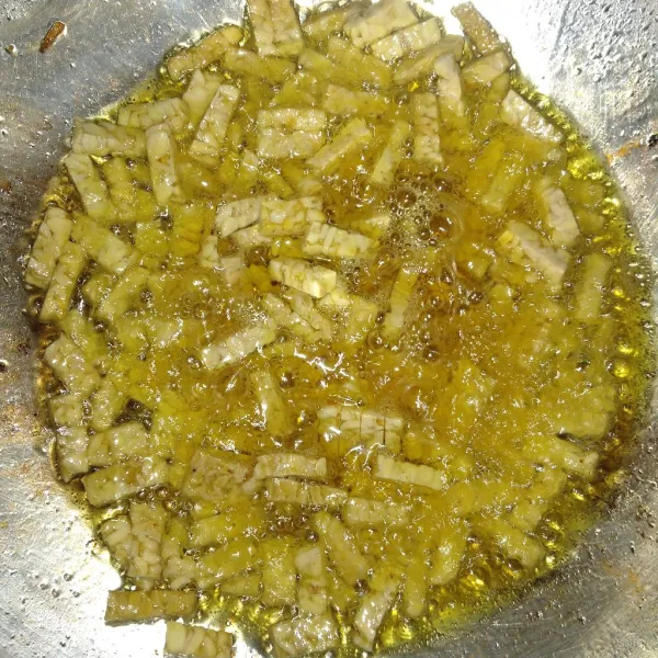Iris tempe kecil-kecil lalu goreng setengah matang.