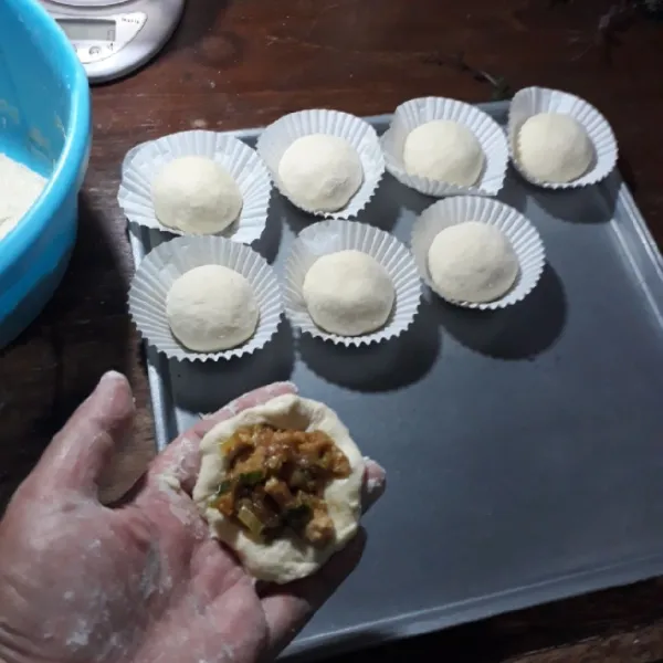 Ambil 40 gram adonan dan pipihkan. Isi dengan unti tahu, rekatkan bagian pinggirnya dan bulatkan. Letakkan di atas kertas.