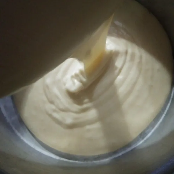 Siapkan loyang, oles mentega tambahkan kertas roti. Kemudian masukan adonan kedalam loyang. Lalu hentakan loyang agar tidak ada udara yg terperangkap dalam adonan