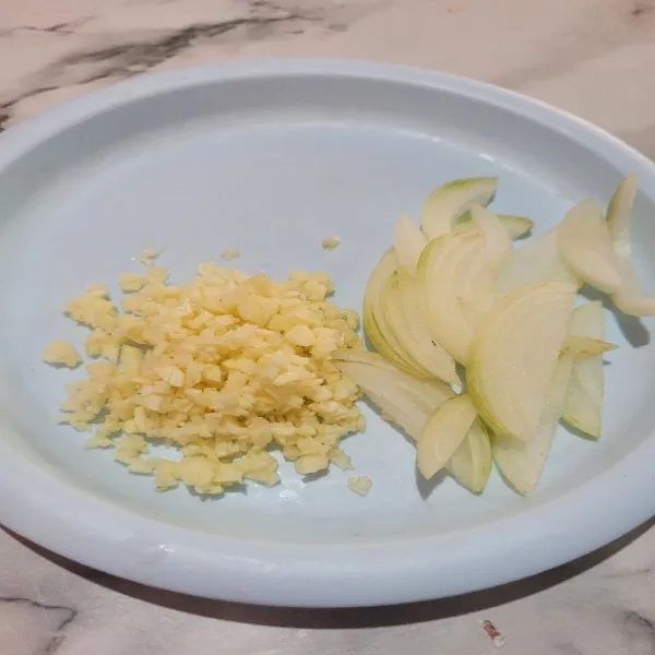Cincang halus bawang putih dan potong bawang bombay memanjang.