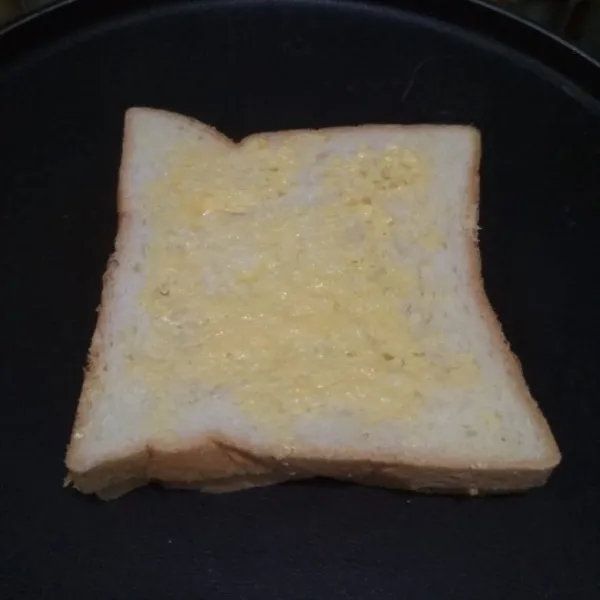 Poles roti dengan margarin.