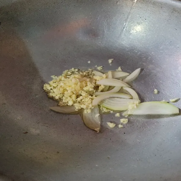 Tumis bawang putih dan bawang bombay hingga layu.