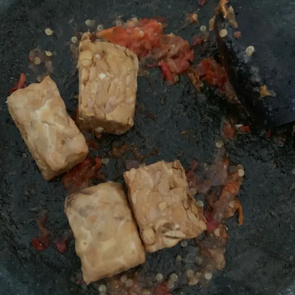 Letakkan tempe di atas sambal kemudian penyet.