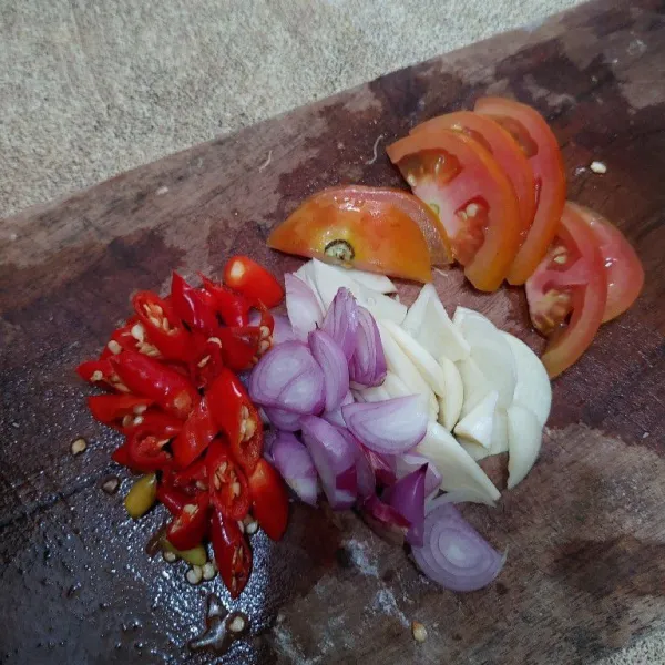 Iris cabe rawit, bawang merah, bawang putih dan tomat.