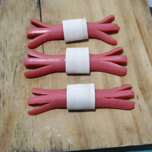 Kerat pinggiran sosis menjadi tiga bagian.