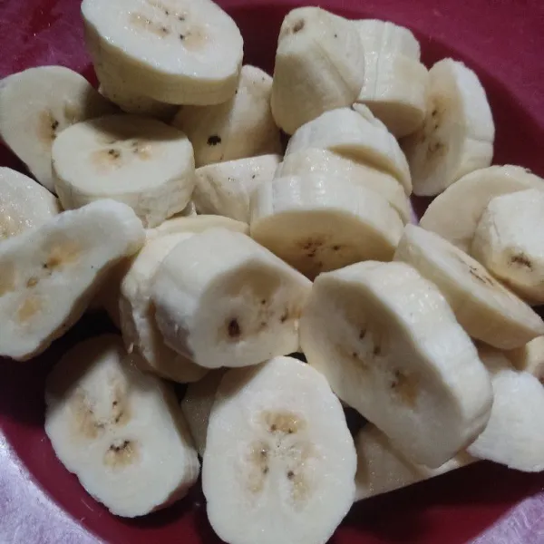 Kupas pisang kemudian potong bulat-bulat.