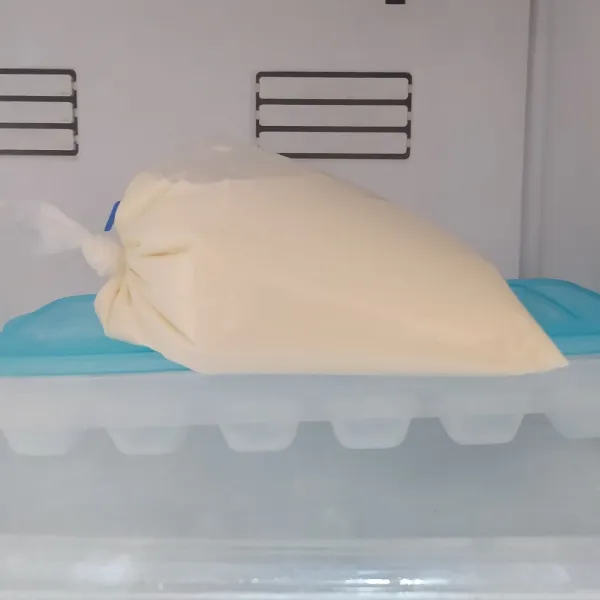 Masukkan susu cair dan susu kental manis ke dalam plastik es, kocok hingga  tercampur rata. Simpan dalam freezer sampai membeku.