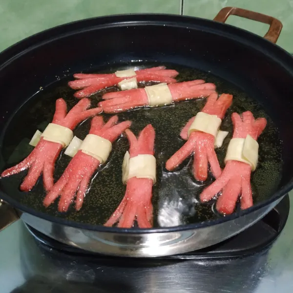Balik sosis perlahan lalu pisahkan jika ada keratan sosis yang menempel. Angkat dan sajikan.