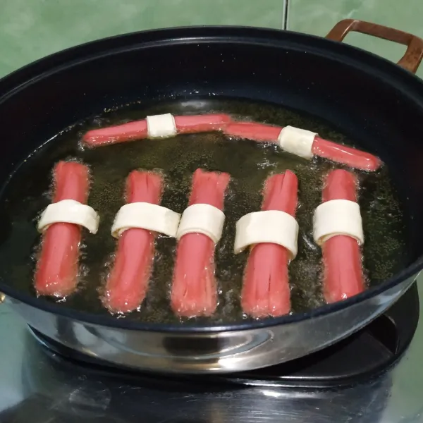 Goreng sosis dengan api kecil hingga sosis mengembang.