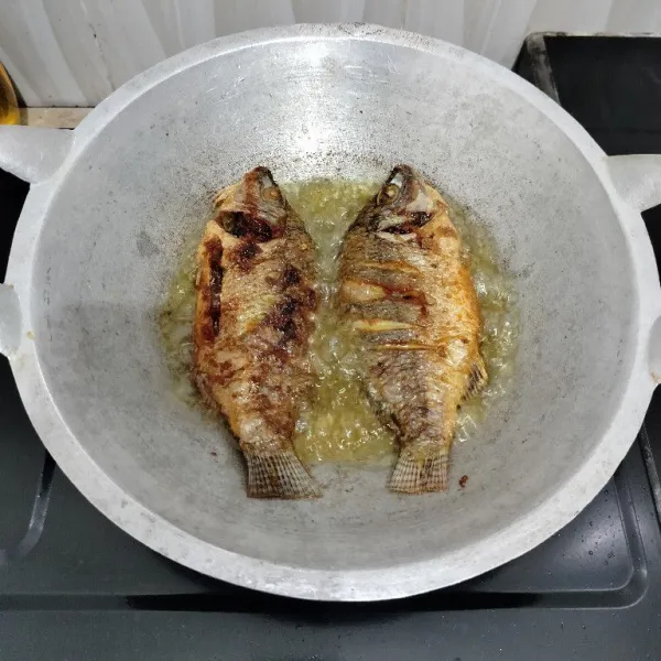Kemudian goreng ikan dalam minyak panas hingga kedua sisinya matang. Angkat dan tiriskan.