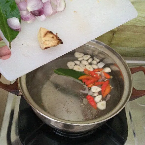 Rebus air hingga mendidih, lalu masukkan bumbu iris, daun salam, lengkuas geprek hingga harum.