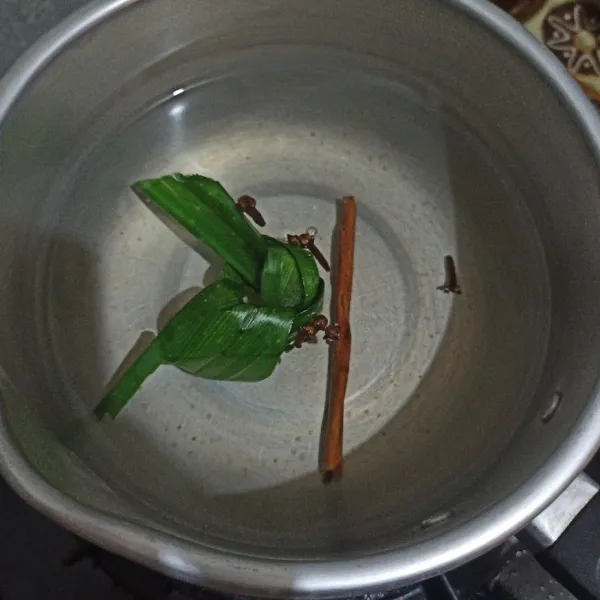 Rebus air bersama daun pandan, cengkeh dan kayu manis. Tunggu mendidih.
