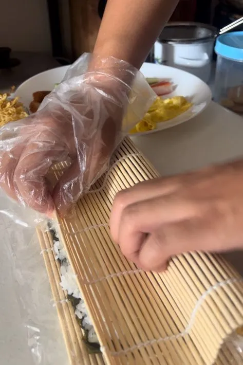 Gulung sushi dari ujung yg diberi topping sampai ujung sampai selesai