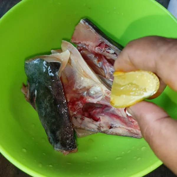 Kucuri ikan dengan jeruk nipis dan diamkan beberapa saat, lalu cuci bersih.