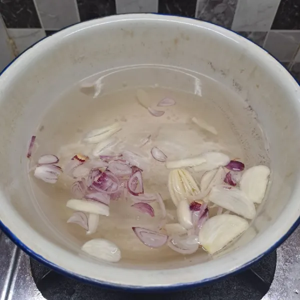 Rebus air sampai mendidih, masukkan irisan bawang merah dan bawang putih. Masak sampai tercium aroma bawang.