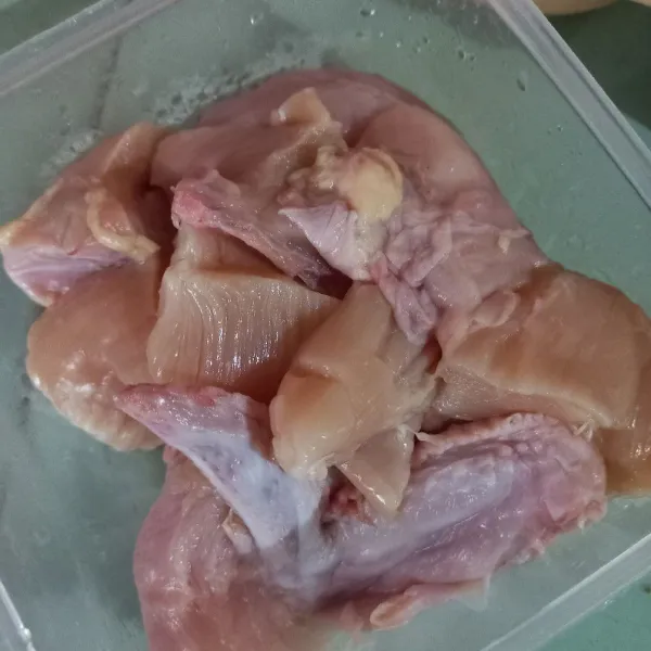 Bersihkan ayam, kemudian potong-potong menjadi 12 bagian.
