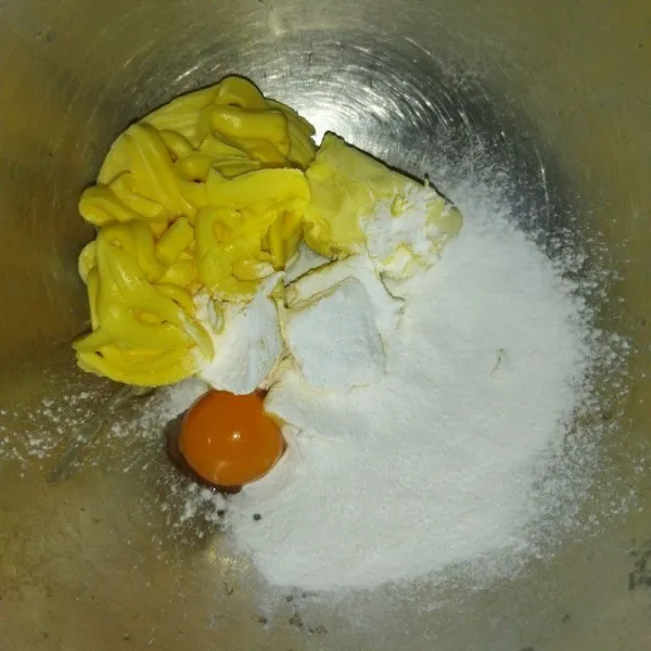 Siapkan wadah, masukkan butter, margarin, kuning telur dan gula halus, aduk hingga tercampur rata.