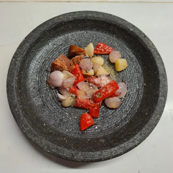 Goreng bawang merah, bawang putih, cabe merah dan cabe rawit sampai layu. Angkat dan taruh dalam cobek. Tambahkan gula merah dan kaldu jamur.
