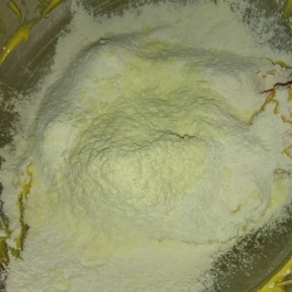 Masukkan tepung terigu dan susu bubuk, aduk dengan sendok kayu hingga tercampur rata.