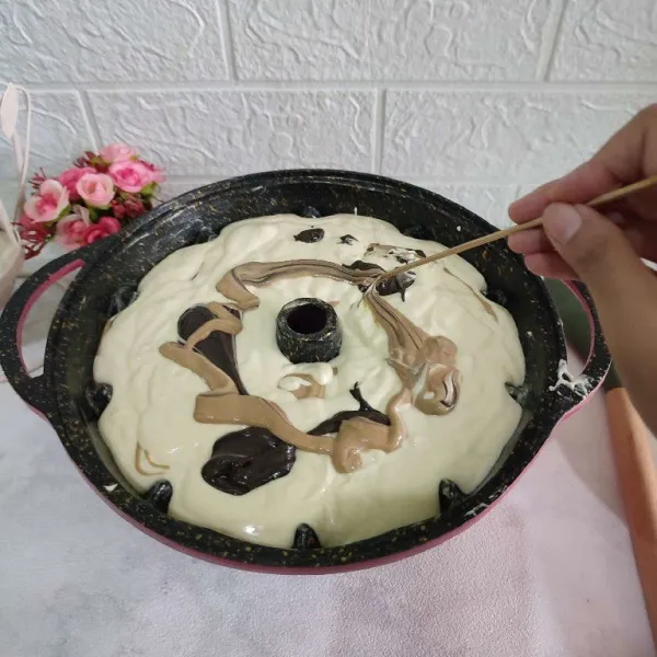 Setelah semua adonan masuk, buat motif dengan bantuan lidi.