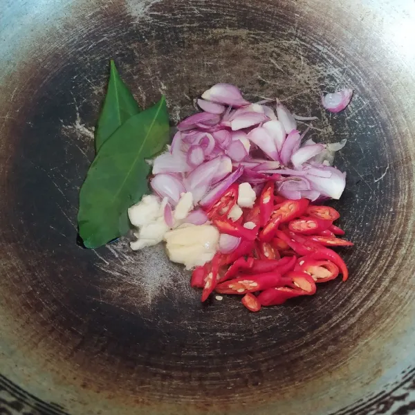 Panaskan minyak, tumis bawang merah, bawang putih, cabai merah keriting, dan daun salam hingga harum dan matang. Gunakan api sedang.