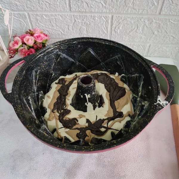 Masukkan adonan ke dalam loyang yang sudah dioles dengan margarin, masukkan berselang-seling dengan adonan yang diberi campuran noir dan pasta mocha.