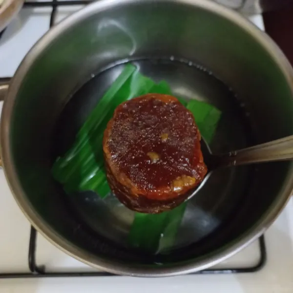 Didihkan air pada panci bersama daun pandan, masukkan gula merah, masak hingga larut.