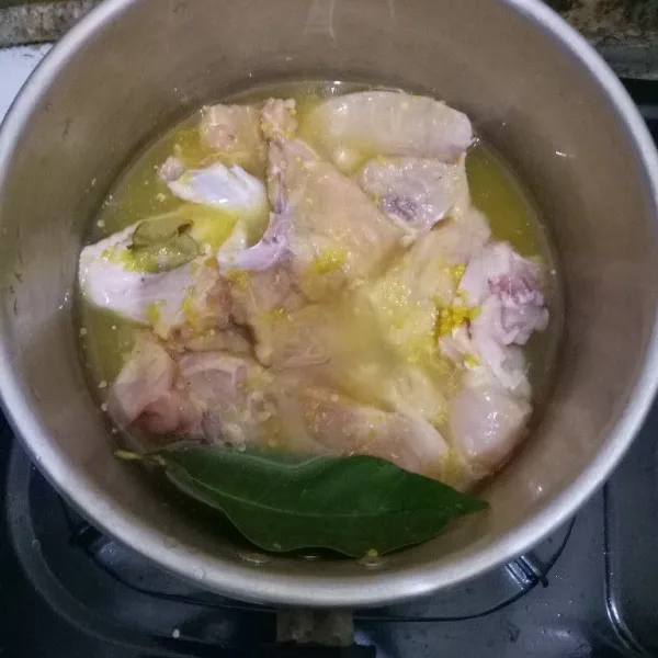Haluskan semua bumbu untuk ungkep ayam kecuali daun jeruk. Lalu taruh ayam, bumbu halus, daun jeruk dan air pada panci. Ungkep selama 15 menit, kemudian matikan apinya dan tutup pancinya. Biarkan hingga airnya hangat.