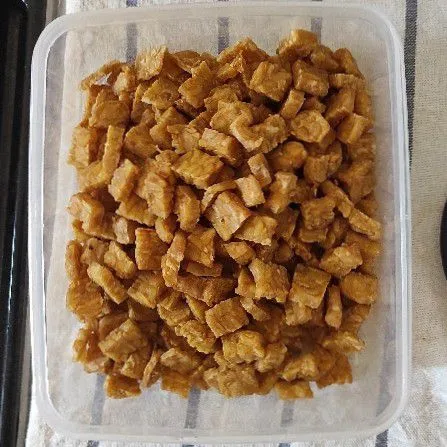 Potong tempe kotak kotak tipis lalu goreng kering