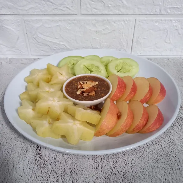 Cuci dan potong buah-buahan. Sajikan buah bersama sambal kacang almond.