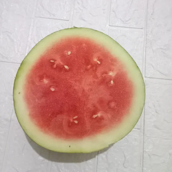 Belah semangka jadi 2 bagian.