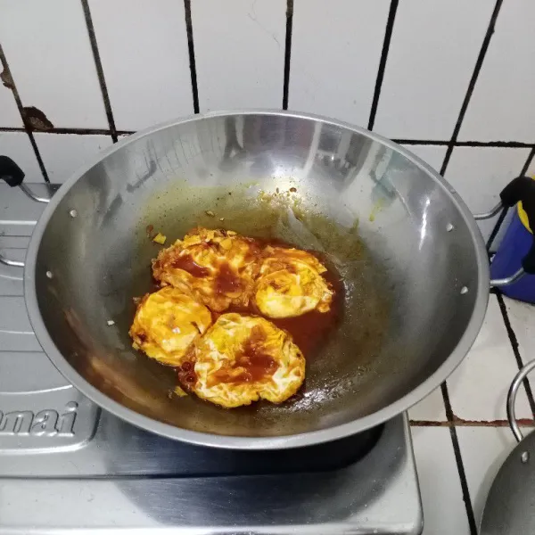 Masukkan telur mata sapi & daun bawang. Aduk rata & masak hingga bumbu meresap. Koreksi rasa. Siap dinikmati