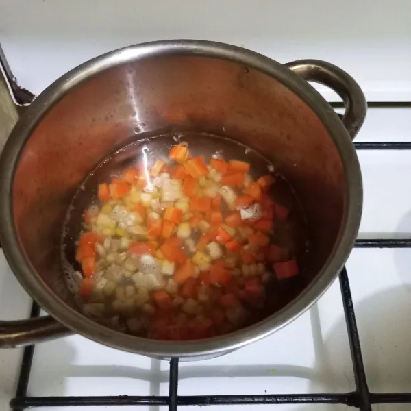 Rebus potongan dadu wortel dan pipilan jagung manis hingga setengah matang.