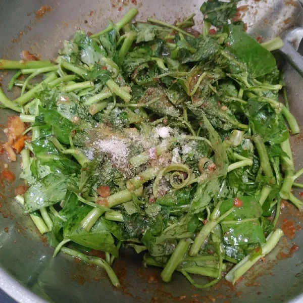 Masukkan kangkung, aduk hingga rata kemudian tambahkan bumbu garam, gula dan kaldu bubuk. Aduk sampai rata.